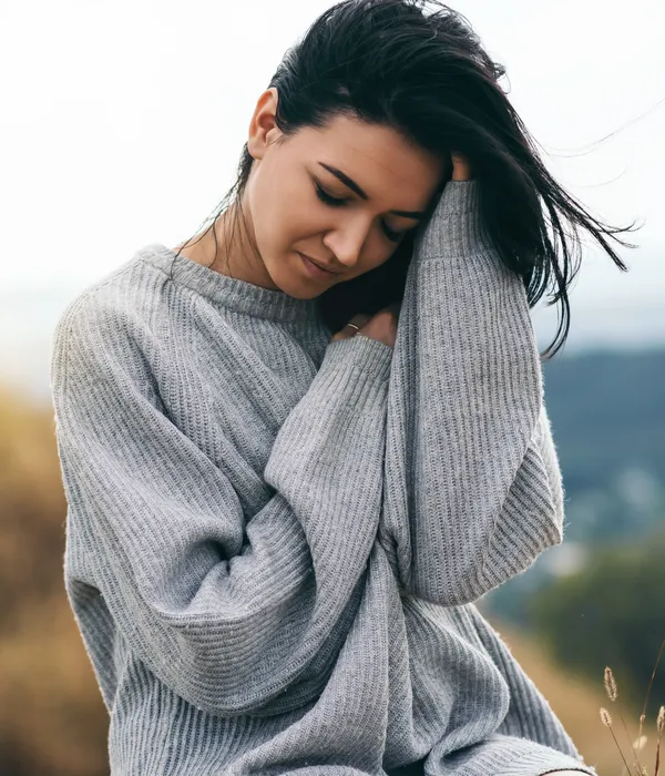 lost angels mental health woman gray sweater sits rock