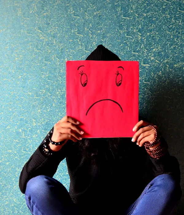 lost angels mental health woman holding red paper sad face