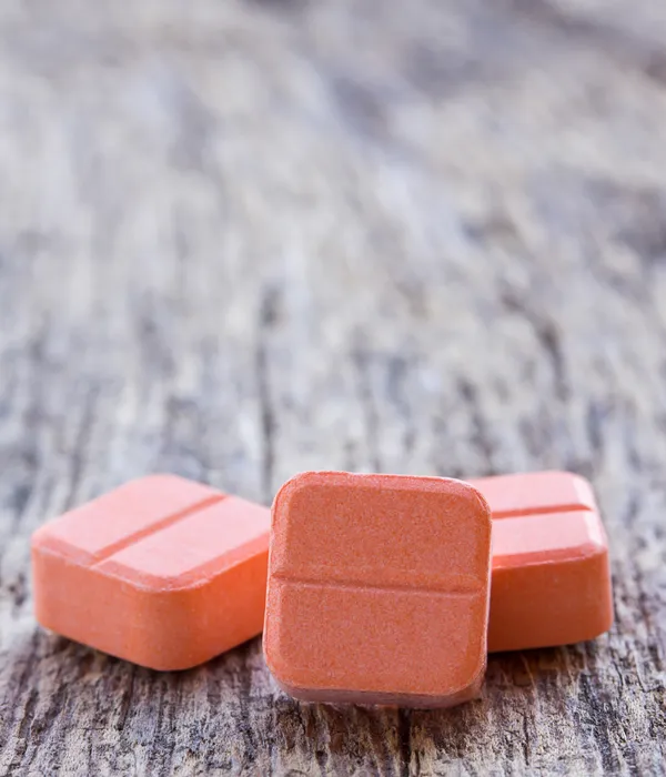 lost angels prescription drug two orange candys wooden table