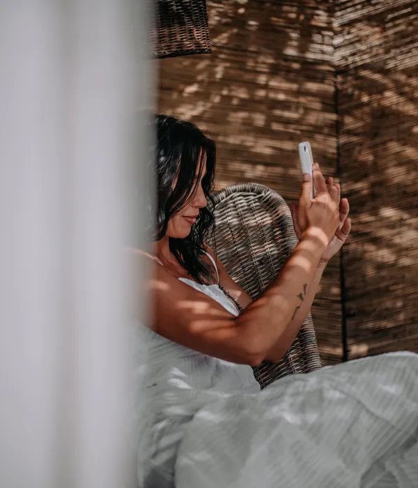 lost angels woman sitting bed using phone sex porn addiction